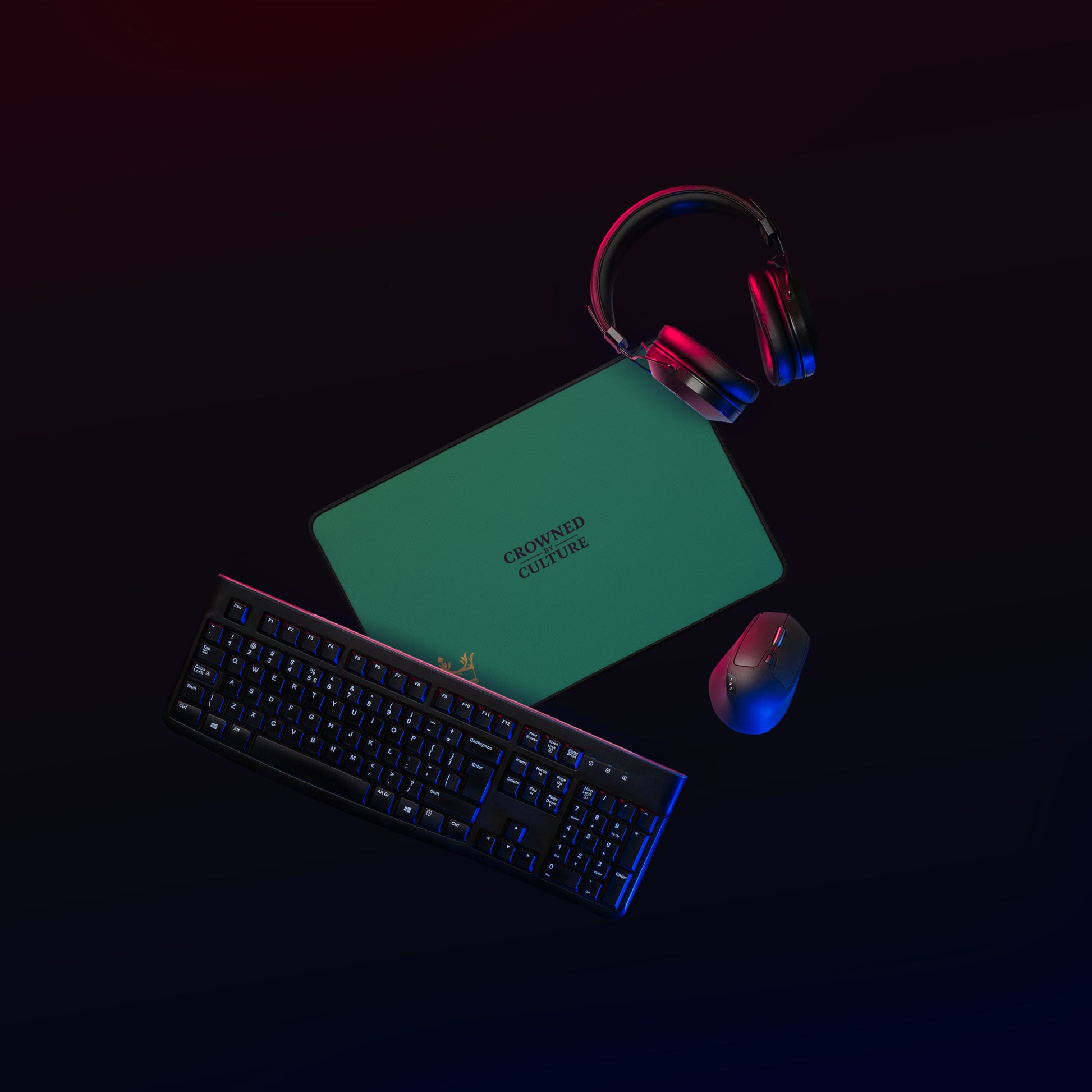 Green CBC desk mat on a dark workstation with keyboard, mouse, and headphones.
