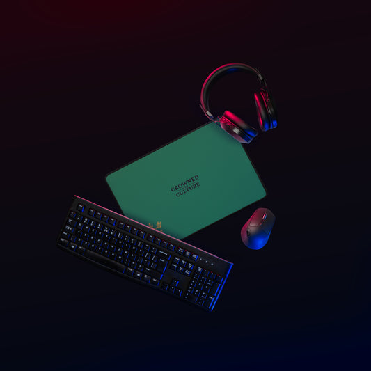 Green CBC desk mat on a dark workstation with keyboard, mouse, and headphones.